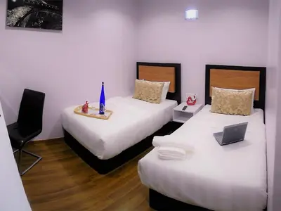 a room with two beds with a laptop on it at Royale Hotel Batu Gajah in Ipoh