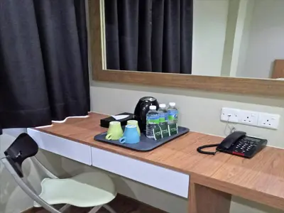 a desk with a phone and water bottles on it at Royale Hotel Batu Gajah in Ipoh