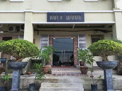 a building with a rock lobby with potted plants in front at Rock Wood Hotel in Sungai Petani