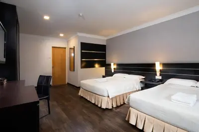 a hotel room with two beds and a desk at Hotel Waterfall in George Town