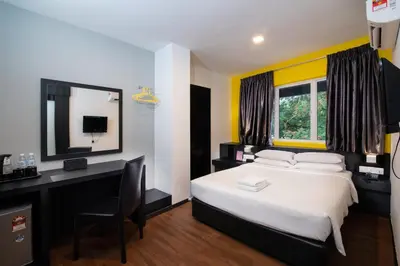 a bedroom with a bed and a desk and a mirror at Hotel Waterfall in George Town