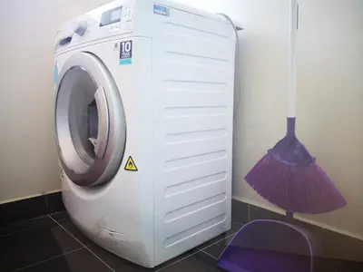 a washing machine in a room with a broom at Penang Studio Suite in Georgetown in George Town