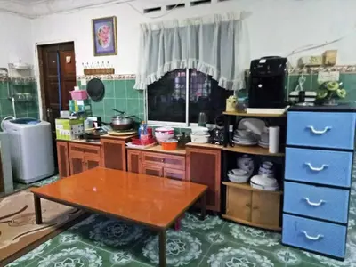 a kitchen with a table in the middle of a room at Farzai Homestay in Lumut