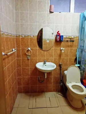 a bathroom with a toilet and a sink and a mirror at Farzai Homestay in Lumut