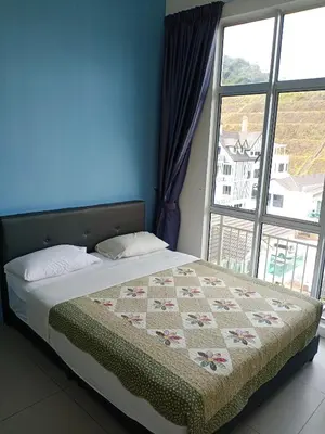 a bed in a room with a large window at Cameron's Square Apartment in Cameron Highlands