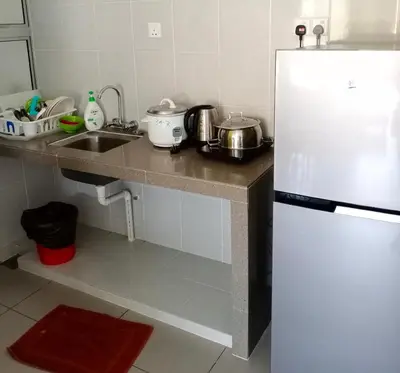 a kitchen with a white refrigerator and a sink at Cameron's Square Apartment in Cameron Highlands