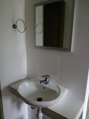 a white sink in a bathroom with a mirror at Cameron's Square Apartment in Cameron Highlands