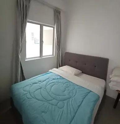 a bedroom with a bed with a blue blanket and a window at Cameron's Square Apartment in Cameron Highlands