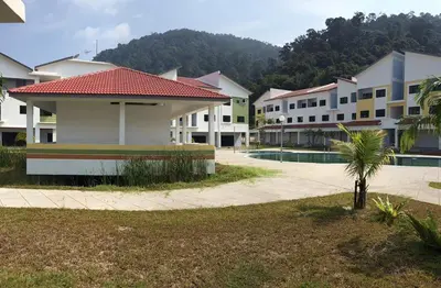 a row of white buildings with a palm tree in a courtyard at Pangkor Lot 10 Vacation Studio in Pangkor