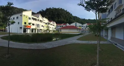 a group of buildings in a courtyard with a tree at Pangkor Lot 10 Vacation Studio in Pangkor