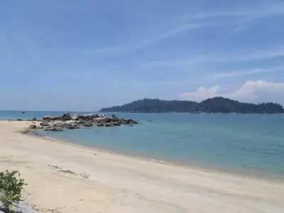a beach with a bunch of rocks in the water at Pangkor Lot 10 Vacation Studio in Pangkor