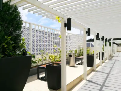 a white pergola on a patio with potted plants at DreamScape Apartment @ Golden Hill in Cameron Highlands