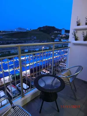 a table and chairs on a balcony with a view of a harbor at Feel Homestay in Cameron Highlands