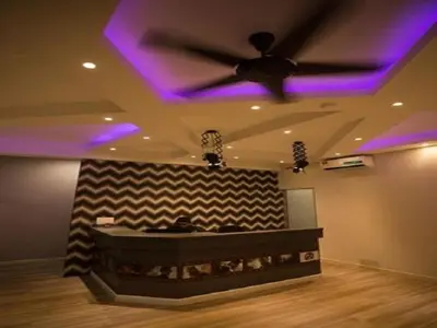 a room with a ceiling fan and purple lights at Hollywood Hotel in Ipoh