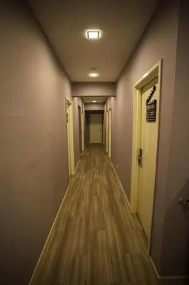 an empty hallway in an office with wooden floors and doors at Hollywood Hotel in Ipoh
