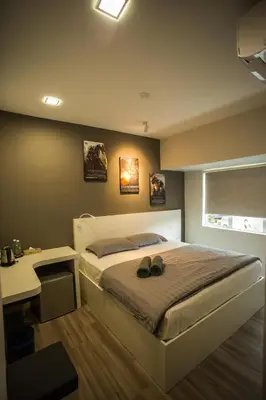 a bedroom with a bed and a desk with shoes on it at Hollywood Hotel in Ipoh