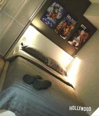 a bedroom with a bed with two pillows and posters at Hollywood Hotel in Ipoh