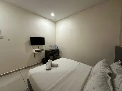 a small room with a bed and a tv at WF Motel in Kulim