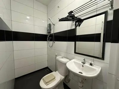 a bathroom with a sink and a toilet and a mirror at WF Motel in Kulim