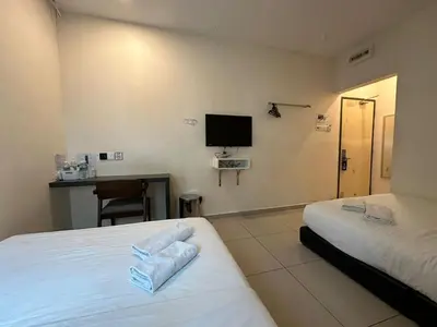 a hotel room with two beds and a television at WF Motel in Kulim
