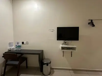 a room with a desk and a television on a wall at WF Motel in Kulim