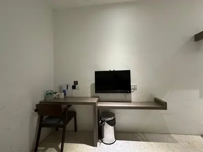 a desk with a television and a chair in a room at WF Motel in Kulim