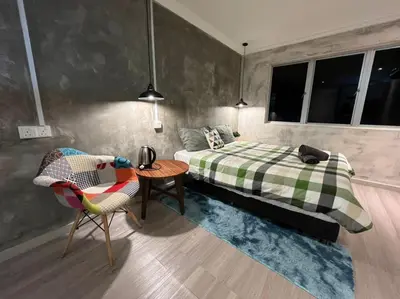 a bedroom with a bed and a table and a chair at YY Residences in Ipoh
