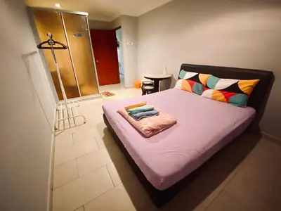 a bedroom with a large bed with pink sheets at YY Residences in Ipoh
