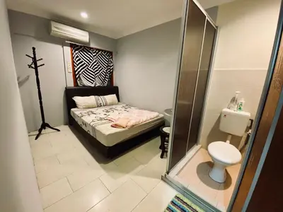 a small bedroom with a bed and a toilet at YY Residences in Ipoh