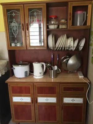 a wooden cabinet with dishes and utensils in it at Kak's House Musl!m Only in Ipoh