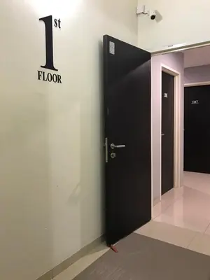 a black door with the number one floor on a wall at Brezza Hotel Sitiawan in Sitiawan