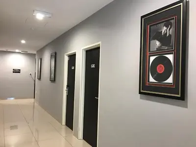 a hallway with a painting of a man on a wall at Brezza Hotel Sitiawan in Sitiawan