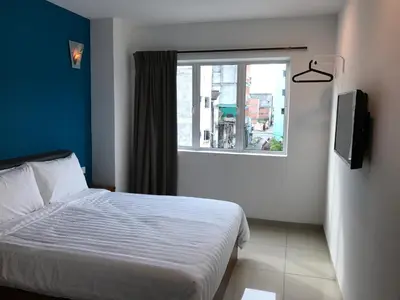 a bedroom with a bed and a window at Brezza Hotel Sitiawan in Sitiawan