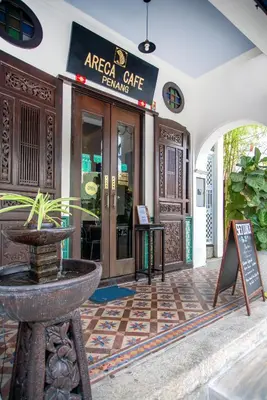 a cafe with a sign in front of a building at Areca Hotel Penang in George Town