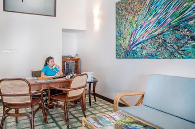 a woman sitting at a table in a room at Areca Hotel Penang in George Town