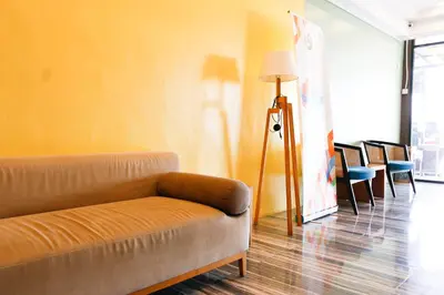a living room with a couch and a lamp at Golden Roof Hotel, Seri Iskandar in Seri Iskandar