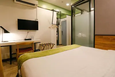 a bedroom with a bed and a desk and a tv at Golden Roof Hotel, Seri Iskandar in Seri Iskandar