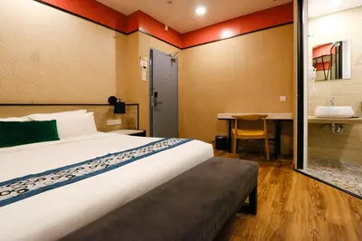 a hotel room with a bed and a table at Golden Roof Hotel, Seri Iskandar in Seri Iskandar