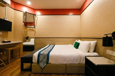 a hotel room with a bed and a desk at Golden Roof Hotel, Seri Iskandar in Seri Iskandar