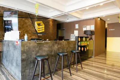 a bar in a lobby with stools at Golden Roof Hotel, Seri Iskandar in Seri Iskandar