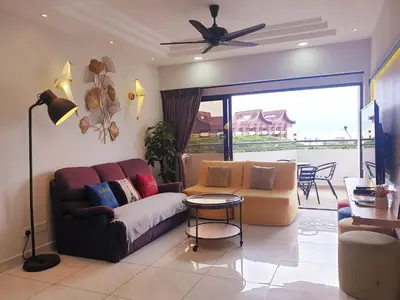 a living room with a couch and a table at Sri Sayang by Coral Holiday Resort in Batu Ferringhi