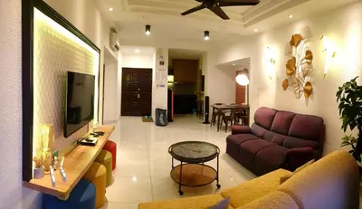 a living room with a couch and a tv at Sri Sayang by Coral Holiday Resort in Batu Ferringhi