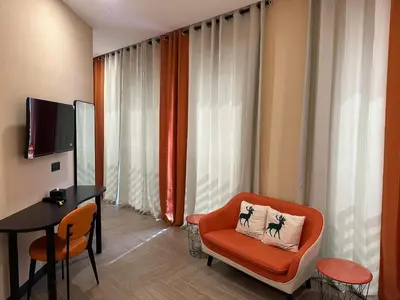 a living room with an orange chair and a desk at S Hotel Seberang Jaya in Perai