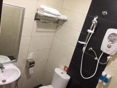 a bathroom with a shower with a toilet and a sink at Hi Star Hotel in Sitiawan