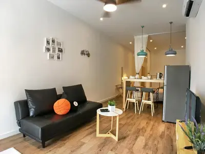 a living room with a black couch and a table at iBook Gurney Suites in George Town