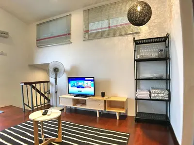a living room with a television and a shelf at iBook Gurney Suites in George Town