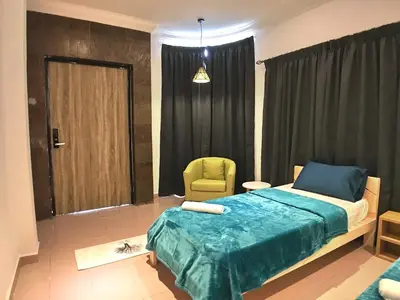 a bedroom with a bed and a chair at iBook Gurney Suites in George Town