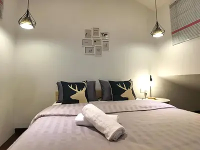 a bedroom with a bed with two pillows at iBook Gurney Suites in George Town
