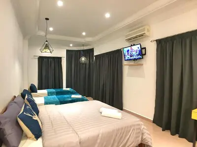 a bedroom with two beds and a flat screen tv at iBook Gurney Suites in George Town