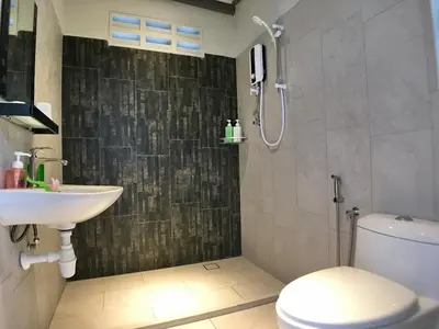 a bathroom with a shower and a toilet and a sink at iBook Gurney Suites in George Town